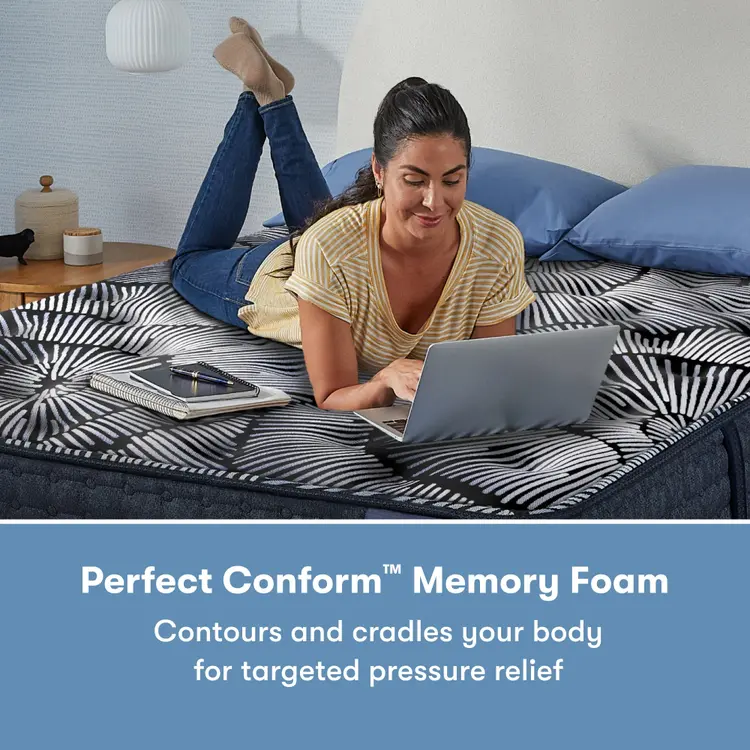 Woman laying on her stomach using her laptop on a Perfect Sleeper X Quilted Hybrid Max Firm Pillow Top Mattress || feel: Firm Pillow Top || level: Level 2