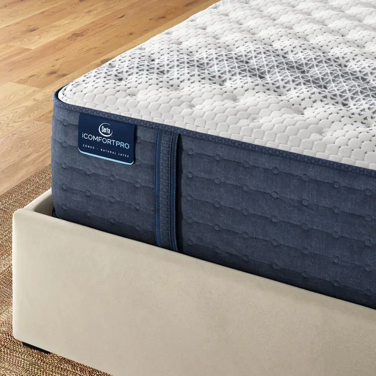 Corner of iComfortPro Kingston Firm Mattress sitting in a brown bedframe || feel: Firm || level: Level 3