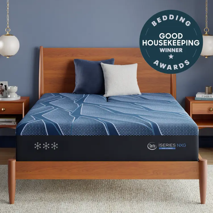A Blue Serta® iSeries® NXG™ Mattress shown on a wooden bed frame in a styled bedroom setting, featuring a blue and white patterned bedding cover, two pillows, bedside tables, and a circular award badge overlay.