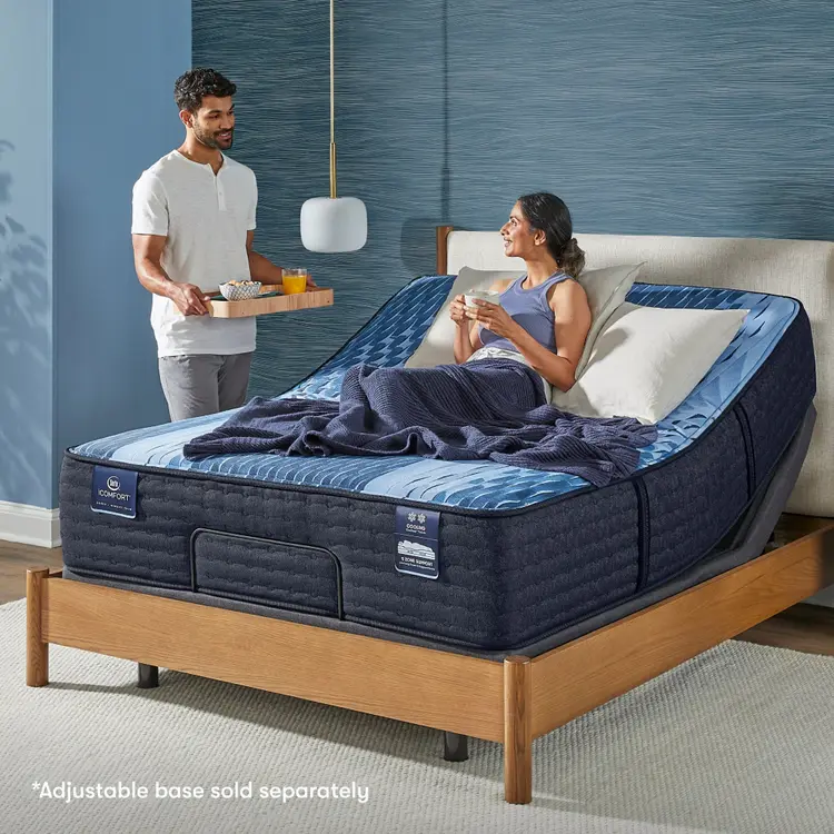 Woman siting in a slightly bent Serta iComfort mattress placed on an adjustable base looking at a man standing at the side serving breakfast in bed || feel: medium || level: Enhanced - 14"